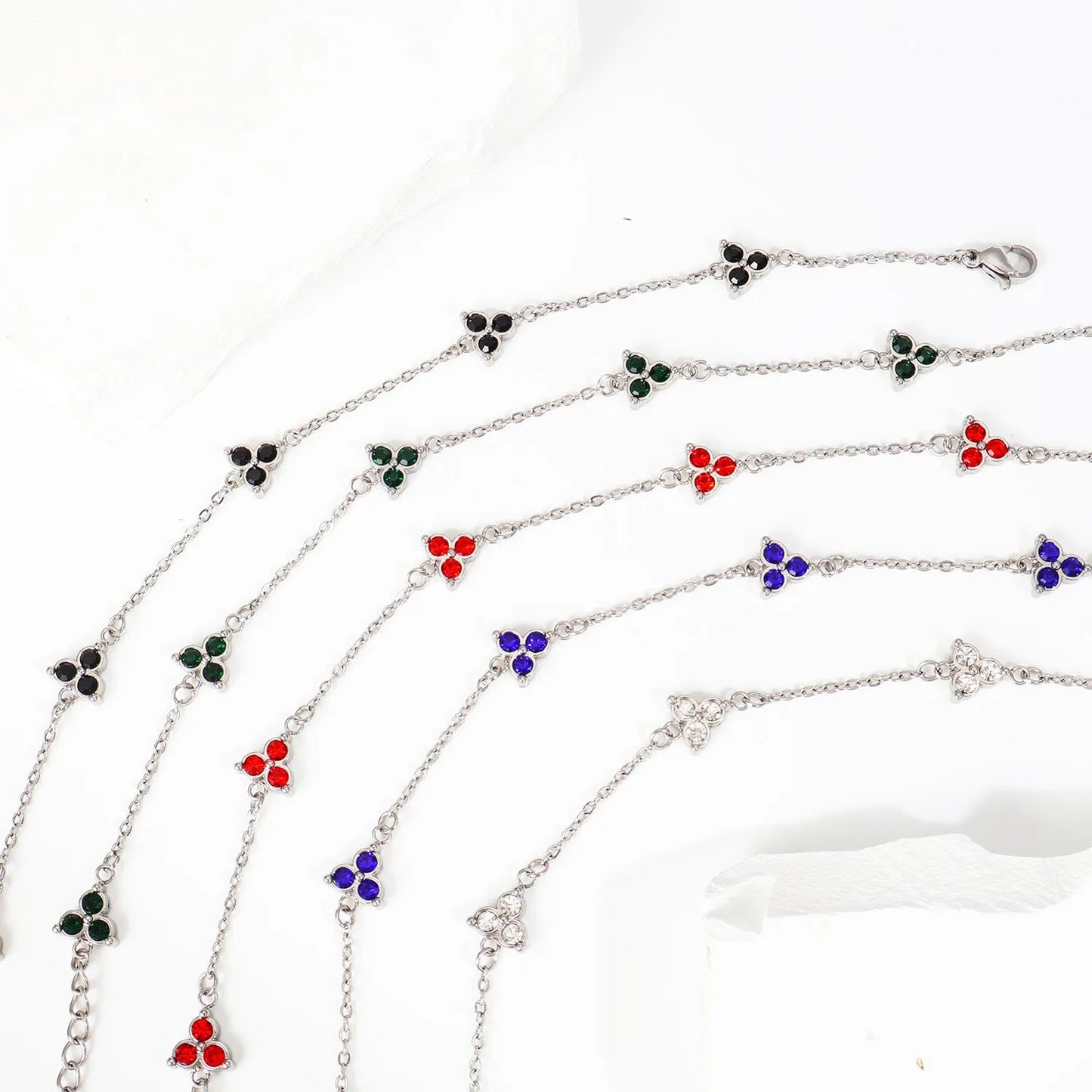 Women's stainless steel bracelet with three triangle-shaped charms in different coloured stone settings