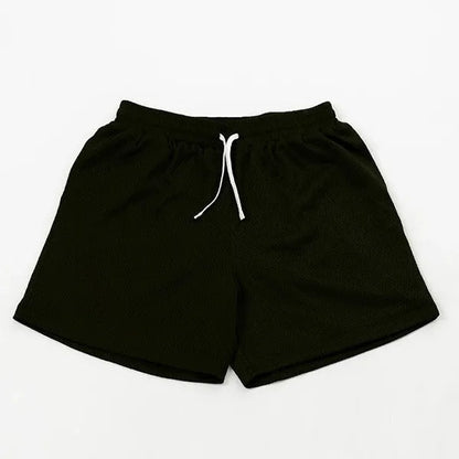 Men's black athletic shorts with grey mesh side panels for breathability, laid flat on a surface.