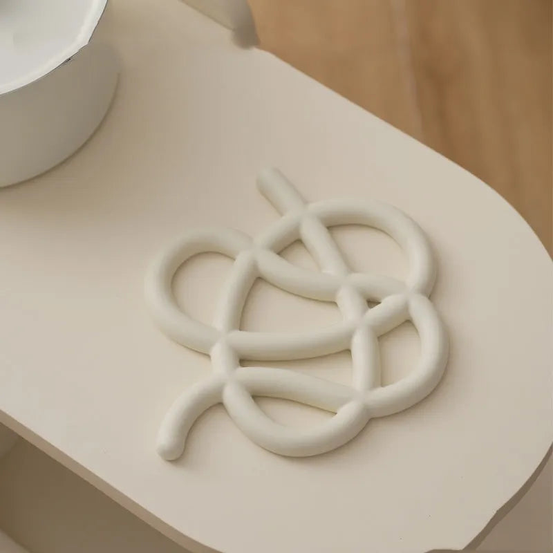 Ceramic heat-proof mat in irregular shape on dining table, protecting surface from hot pot