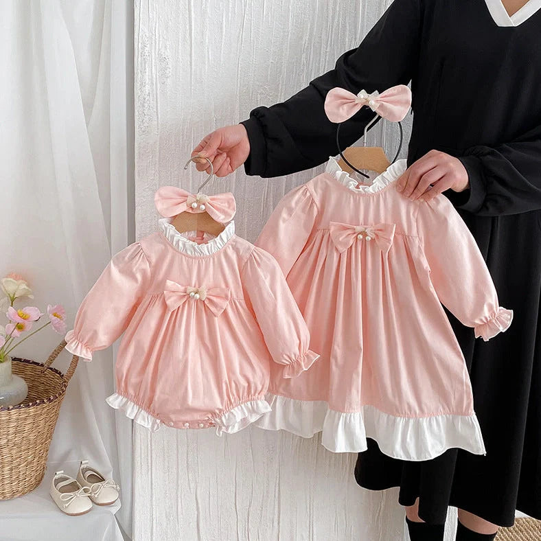 Girl wearing peach branch climbing colour triangle jumpsuit with princess dress styling and matching headband