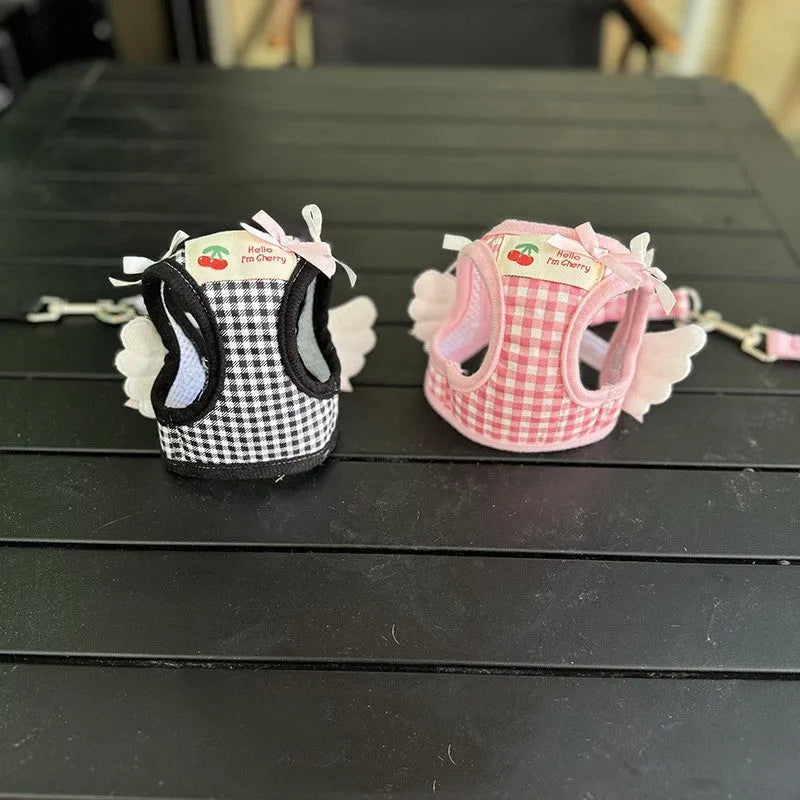 Small dog wearing adjustable cotton harness in pink with chest-back design and hand holding rope attachment