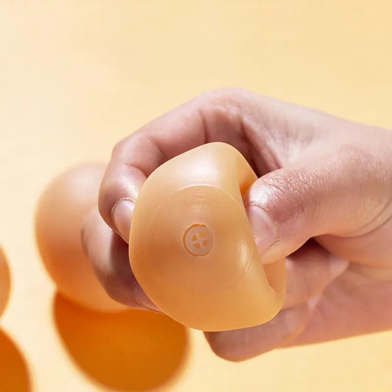 Pink rubber simulation egg dog toy with a textured surface for chewing.