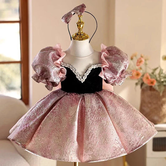 Pink children's princess dress with cute design elements, shown on hanger