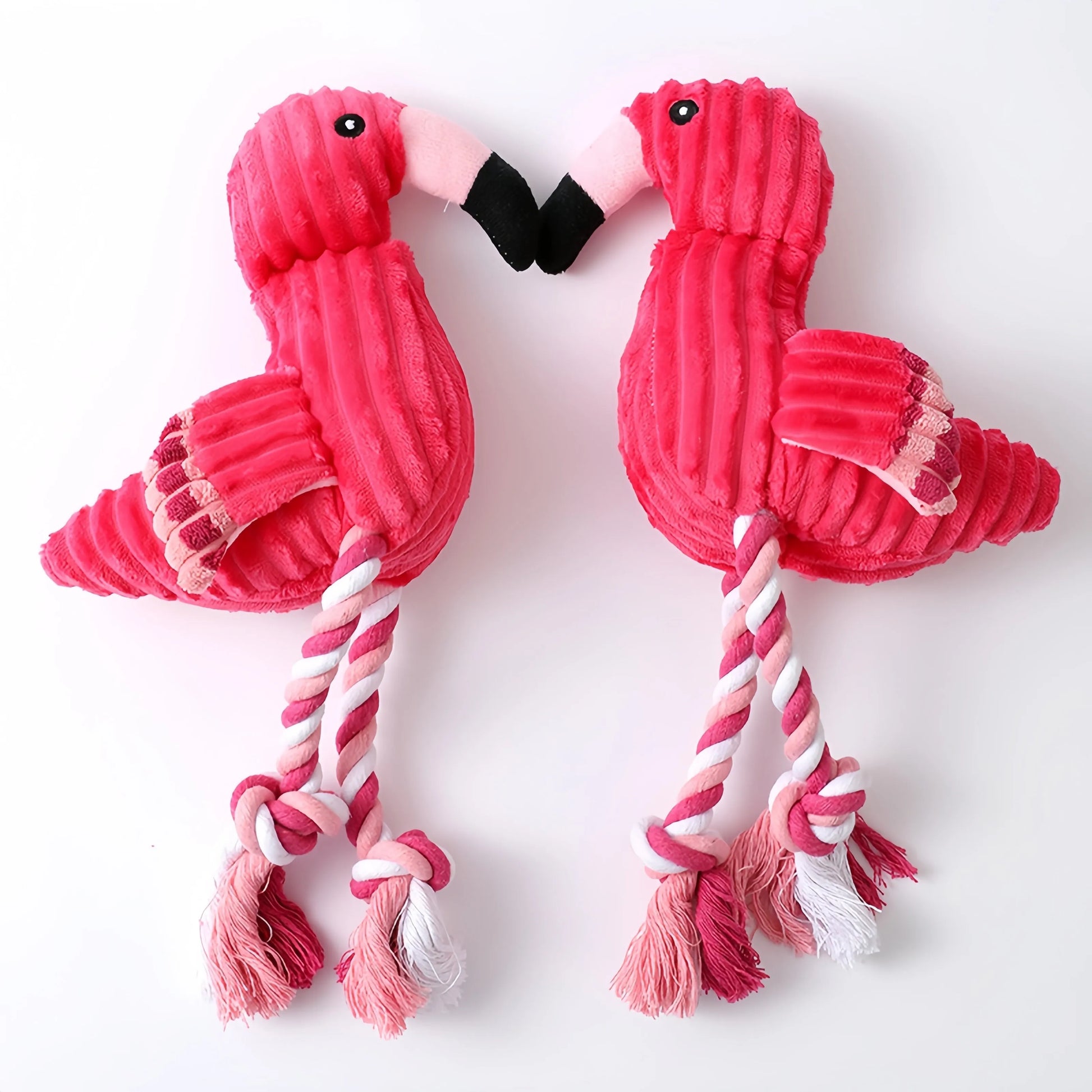 Four pink animal-shaped corduroy dog toys with squeakers arranged together