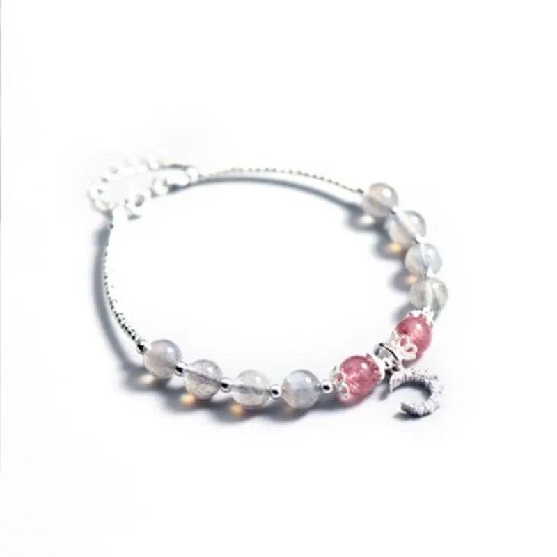 Natural moonlight-coloured moonstone bracelet with silver crescent moon charm on adjustable chain.