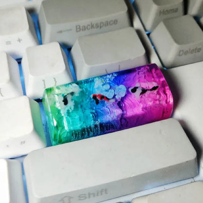 Close-up of a custom resin keycap featuring a detailed blue and orange koi fish scene, designed for Cherry MX mechanical keyboards.