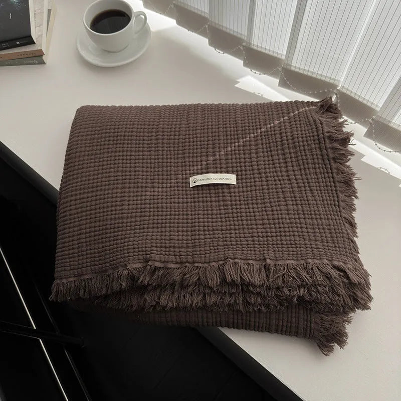 Four-layer gauze tassel blanket in cotton, showing tassel edges and textured fabric, available in multiple colours and sizes