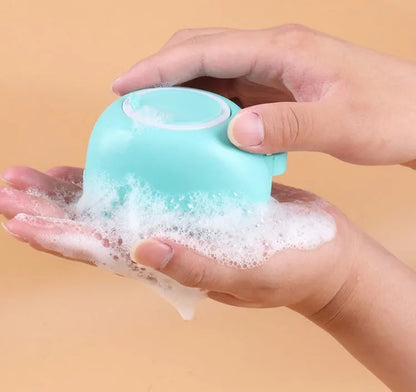 Blue silicone dog bath and massage brush held in a hand.