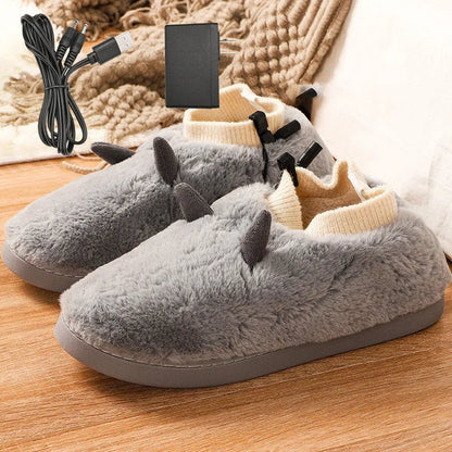 USB-powered electric slippers in black with a connected USB cable, showing soft velvet upper and plastic sole.
