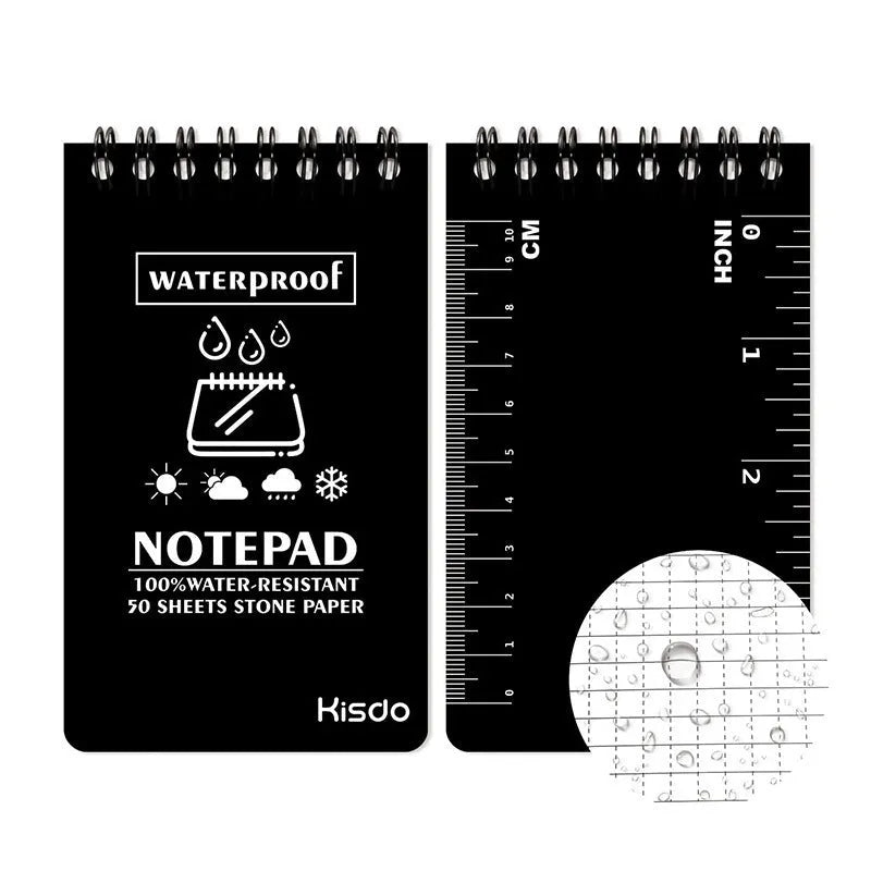 Spiral-bound waterproof notepad in camouflage colour, open on a desk with a pen, showing stone paper pages.