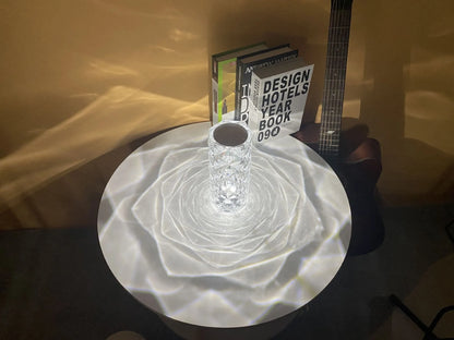 Modern minimalist acrylic crystal rose LED table lamp with touch switch on a wooden table.