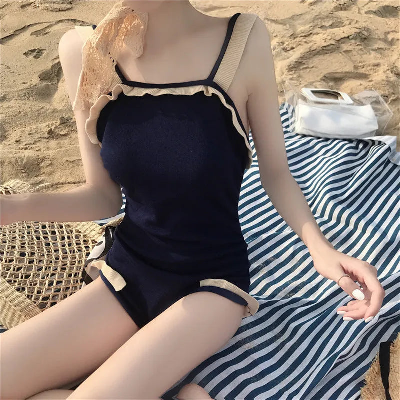 Women's conservative one-piece swimsuit in nylon fabric showing colour options including black with white edge trim