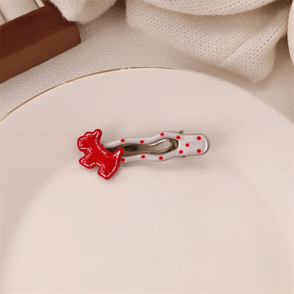 Red plastic hair clip with a 3D love heart and dots on a willow leaf-shaped base.
