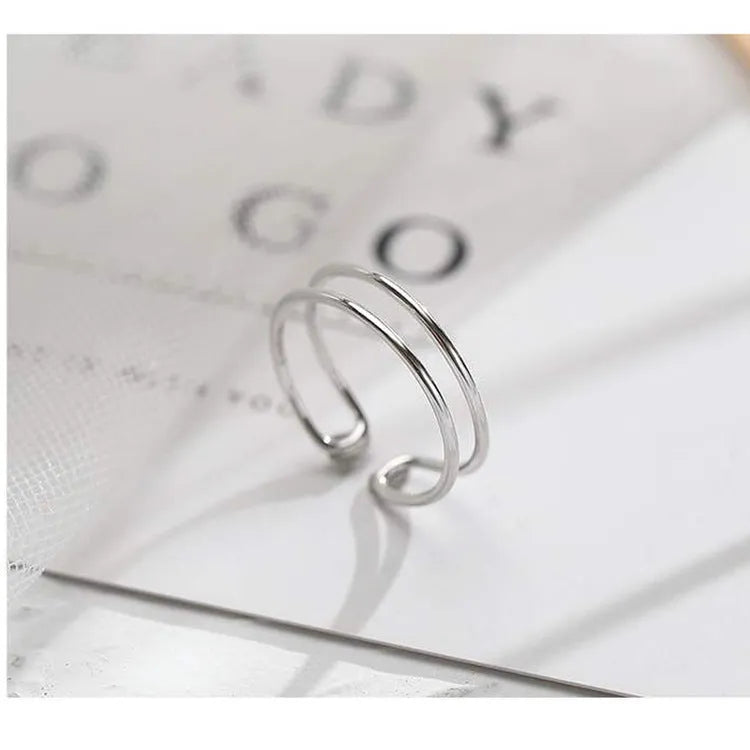 Adjustable silver plated geometric cross ring for women in gold tone or silver tone on a copper base.