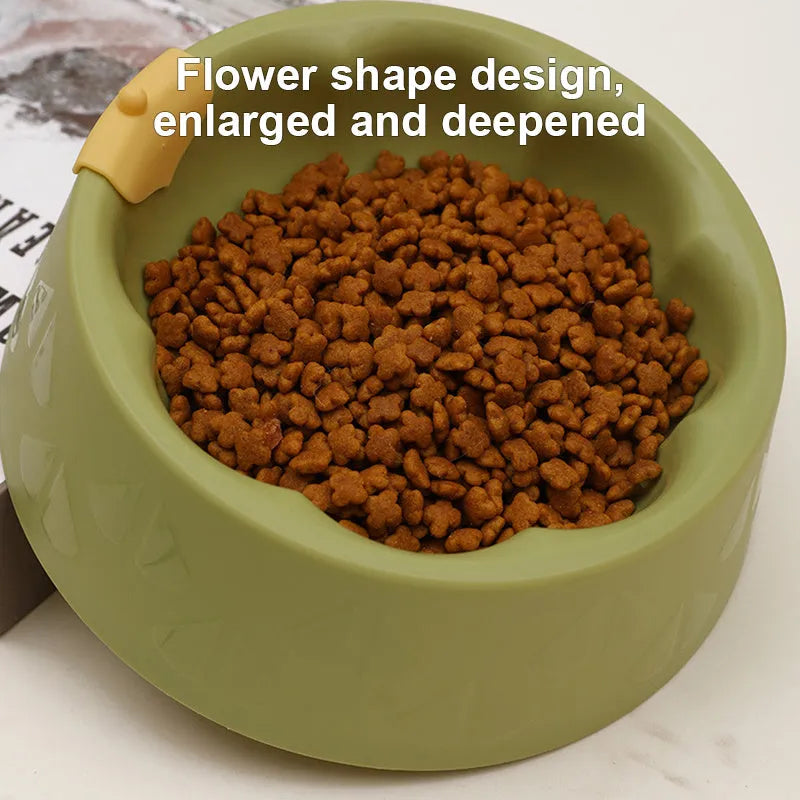 Green plastic double pet bowl with two compartments for food and water on a flat surface.