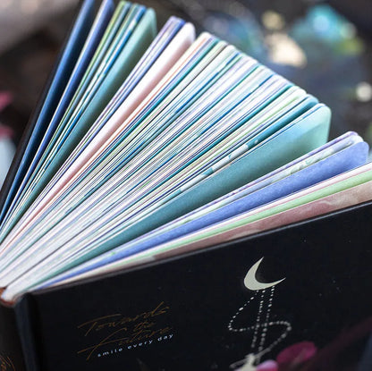 A5 notebook with luminous cover in Deep Blue, open to show 100 gsm paper and colour illustrations