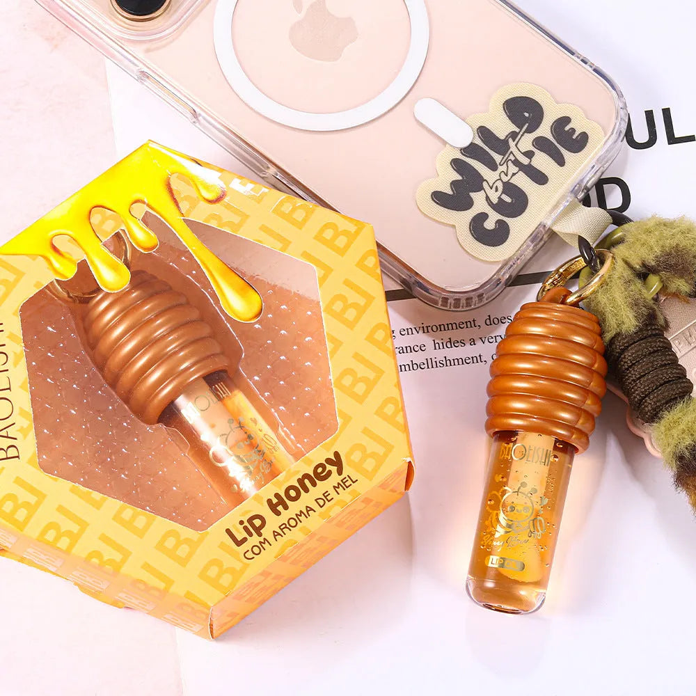 Moisturising honey lip gloss on a silver keychain against a plain background.