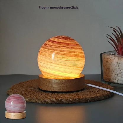 Planet-shaped USB night light with adjustable dimming in 12 colour options on its base.