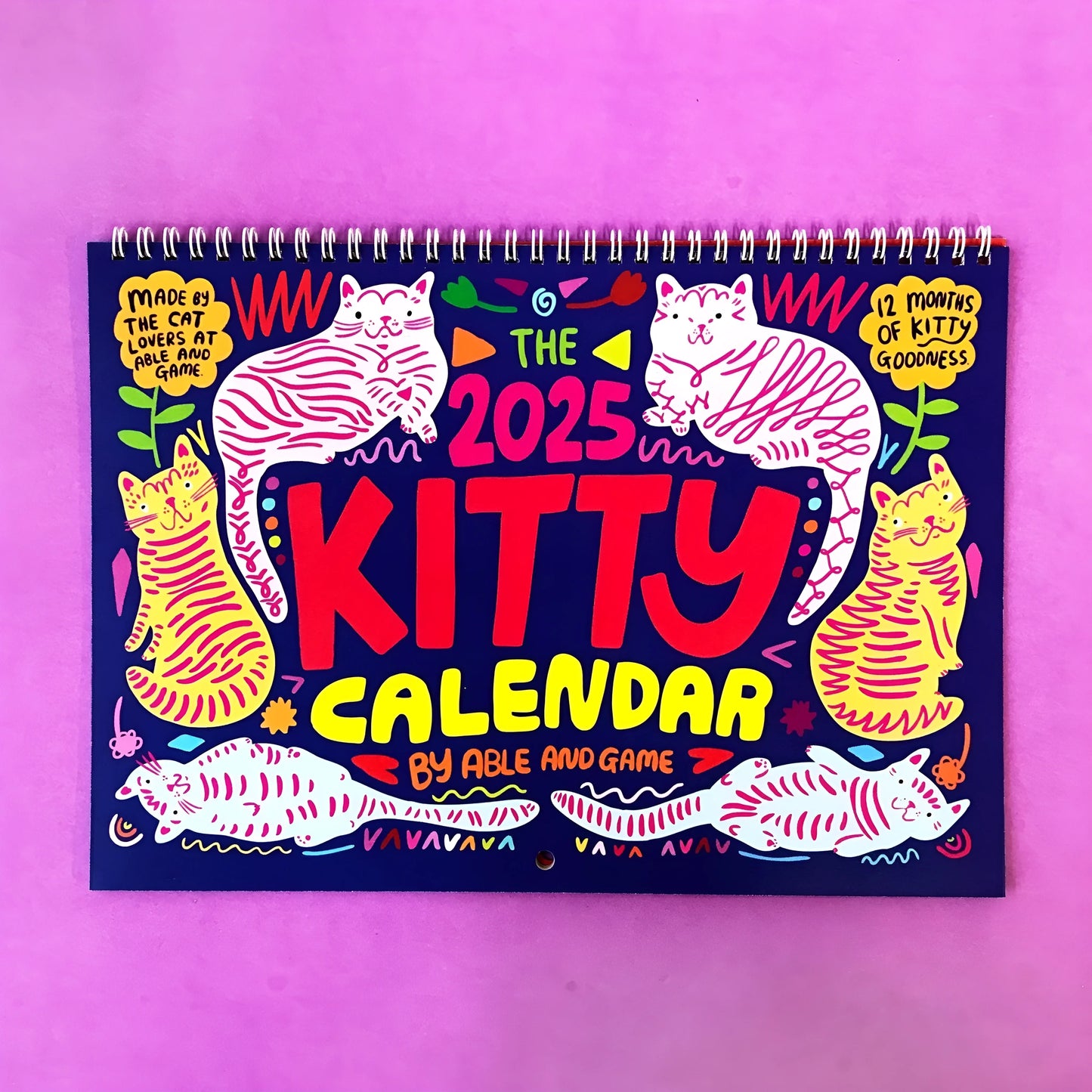 Cat-themed paper wall calendar for 2024 or 2025 year, showing monthly grid with feline artwork.
