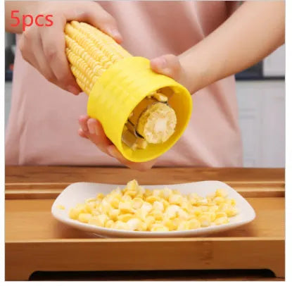 Yellow manual corn grinder thresher with corn-shaped design and stainless steel gear for peeling corn kernels.
