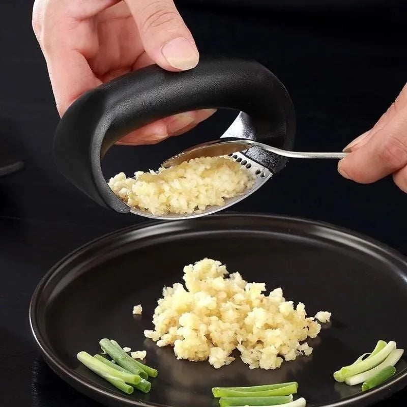 Stainless steel garlic press with ergonomic handle in kitchen setting