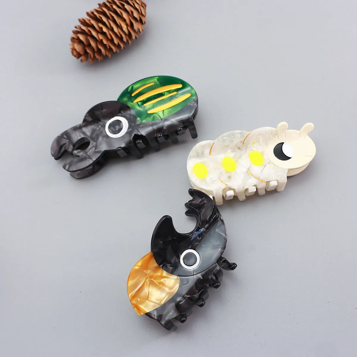 Handmade cartoon insect beetle grip hair clip or brooch in green, orange, or white designs.