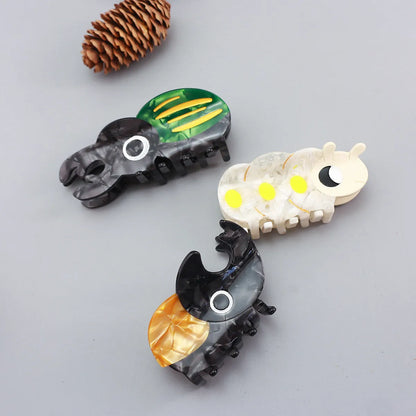 Handmade cartoon insect beetle grip hair clip or brooch in green, orange, or white designs.