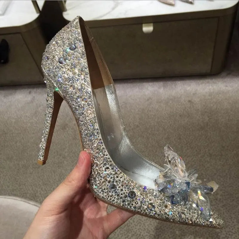 Women's gold pointed toe high heels with rhinestones and stiletto heel on a light background