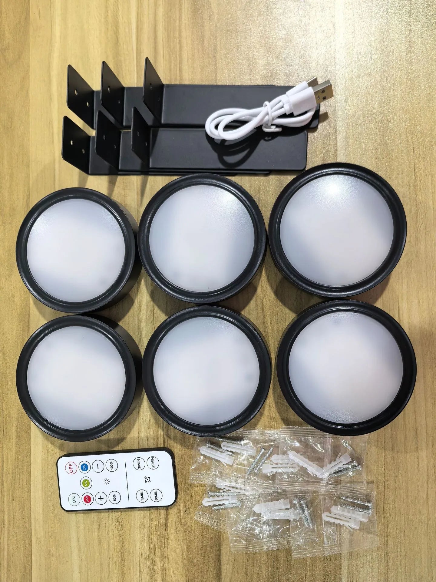 Black magnetic LED painting lamp with remote control on a white wall.