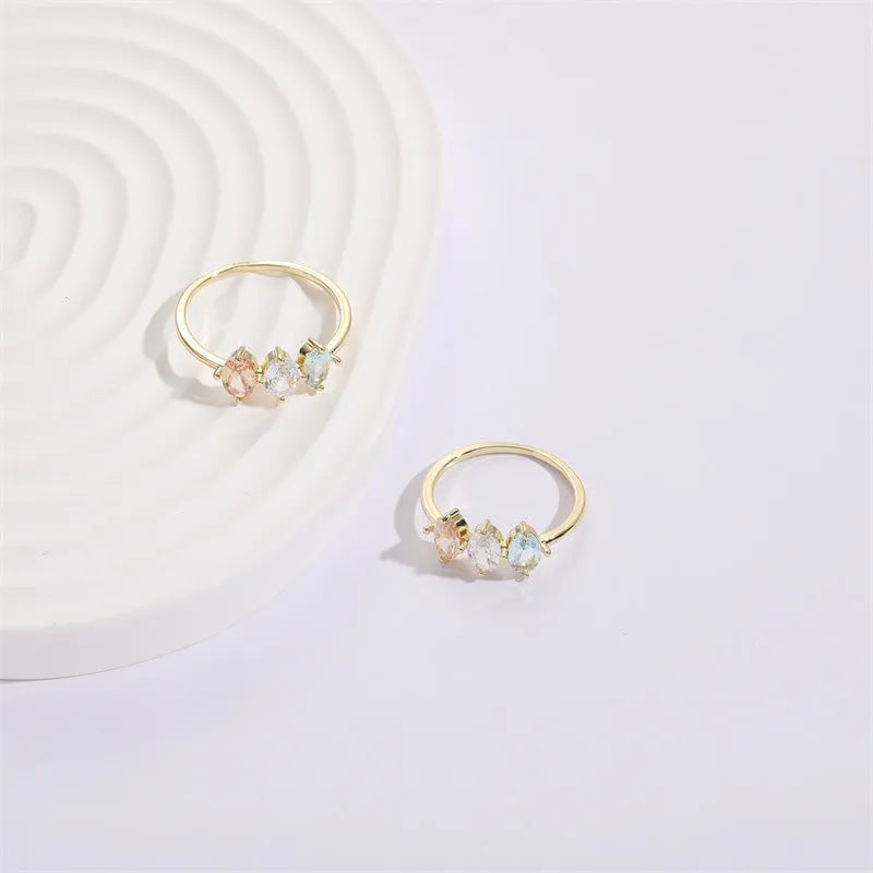 Geometric women's copper ring with triangle design, tricolour zircon stones, and birthstone in electroplated gold finish