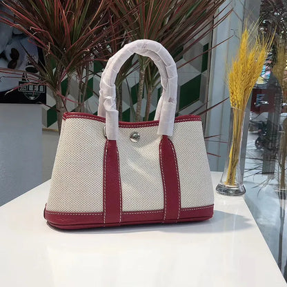 Genuine leather and canvas women's tote bucket bag in black, shown with a soft carry handle.