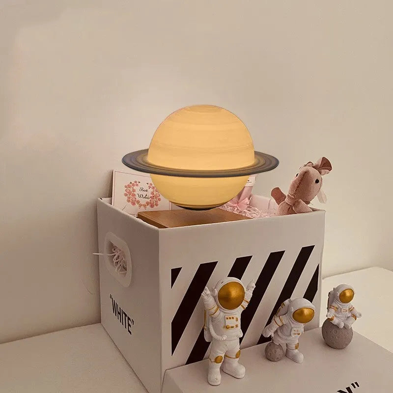 Maglev floating night light with glowing moon and planet designs on a table.