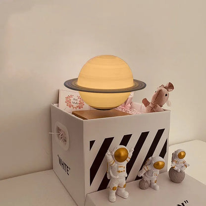 Maglev floating night light with glowing moon and planet designs on a table.