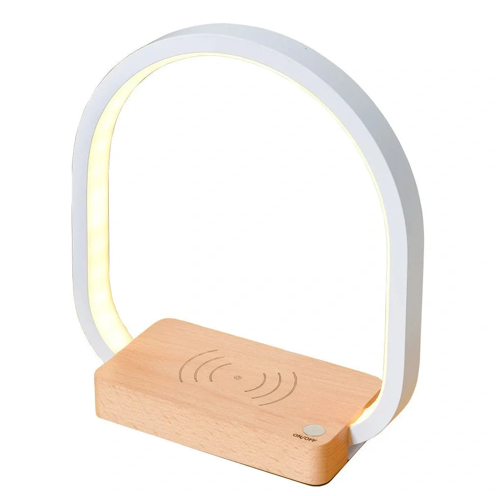 White wireless charging table lamp with metal shade and button switch on wooden surface
