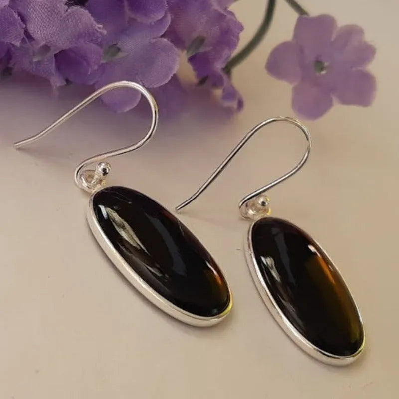 Women's geometric earrings with a black oval agate pendant in a silver electroplated frame.