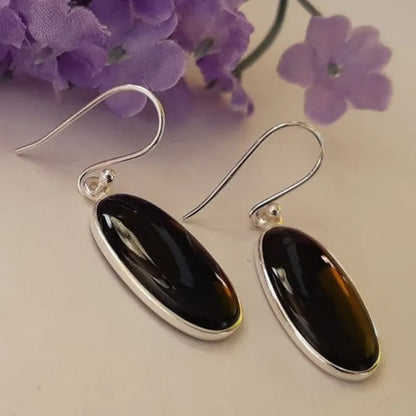 Women's geometric earrings with a black oval agate pendant in a silver electroplated frame.