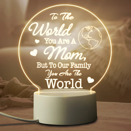 Modern minimalist white LED night light with acrylic shade and USB cable on a wooden surface