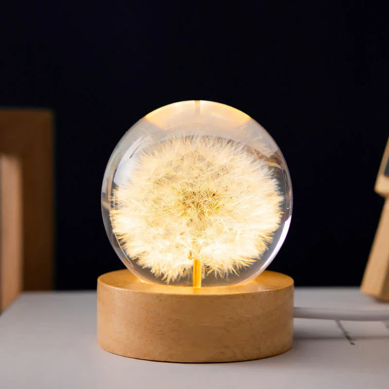 Enchanting 3D dandelion, yellow daisy, or red daisy flowers suspended in a clear crystal ball with a beech wood base, creating a mesmerizing desktop decor piece.