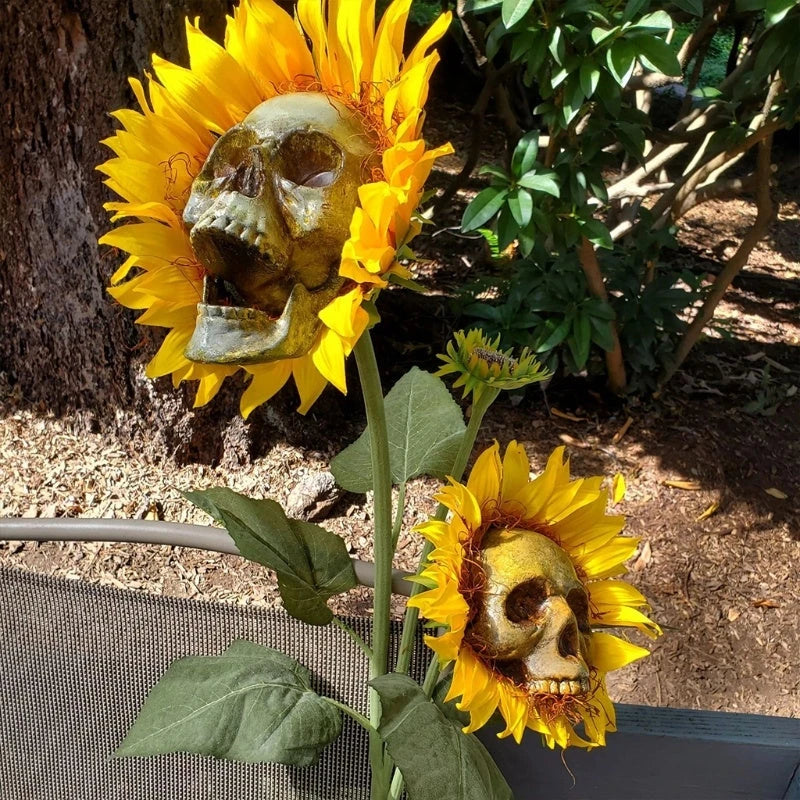 A group of skull-shaped sunflower ornaments arranged in a Halloween-themed outdoor display