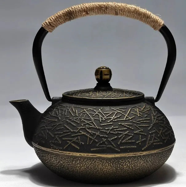 Japanese-style cast iron teapot with lid on a hob, shown in a bronze finish.