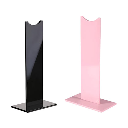 Pink detachable head-mounted gaming headset stand with non-slip silicone base on a desk