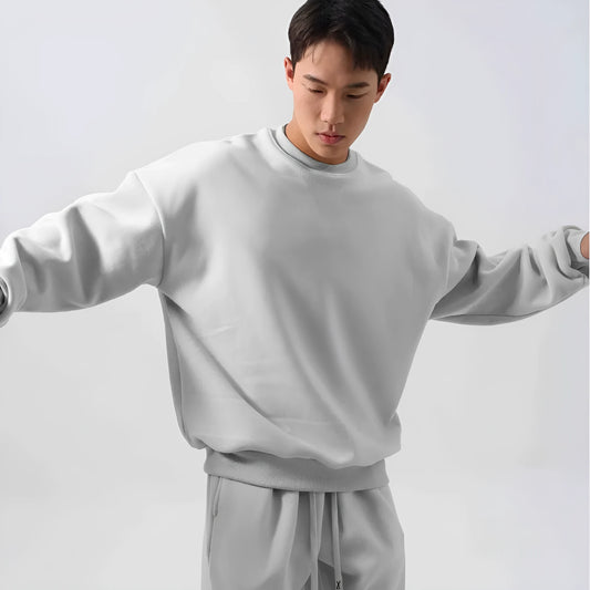 Man wearing a two-piece army green polar fleece suit with crew neck top and padded trousers.