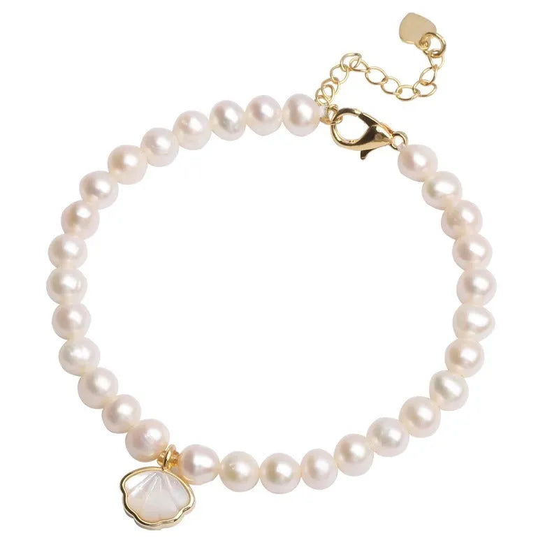 Women's freshwater pearl bracelet with fan-shell centrepiece on a 16cm elastic string or extension chain.