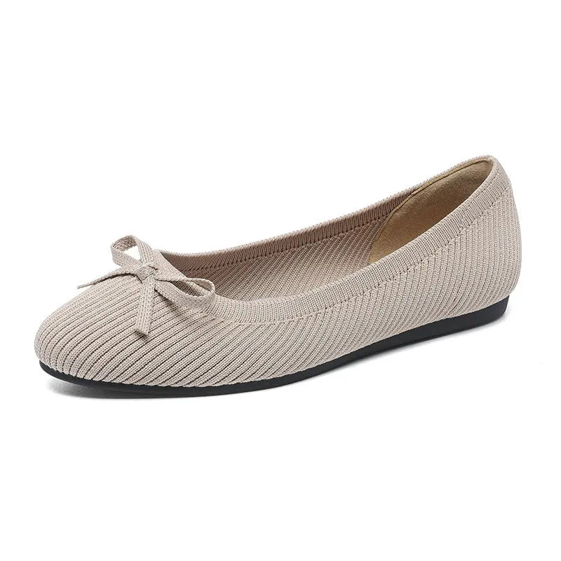 Women's black fabric flat pumps with a bow detail on the round toe, shown on a white background.