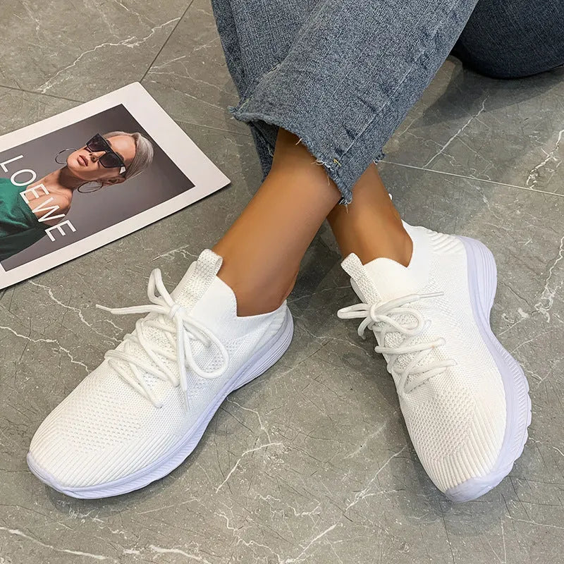 Women's low-top mesh Flyknit tennis shoes in creamy white, with a rubber sole and round toe.
