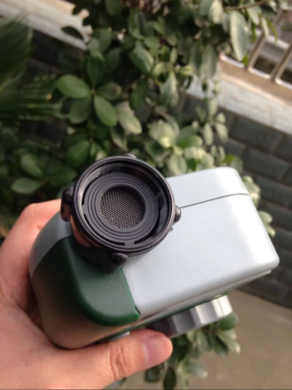 Green digital garden hose timer with LCD screen and dual hose outlets.