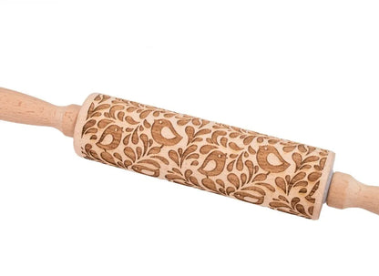 Wooden rolling pin with engraved Christmas patterns including reindeer and snowflakes on a 45cm long barrel.