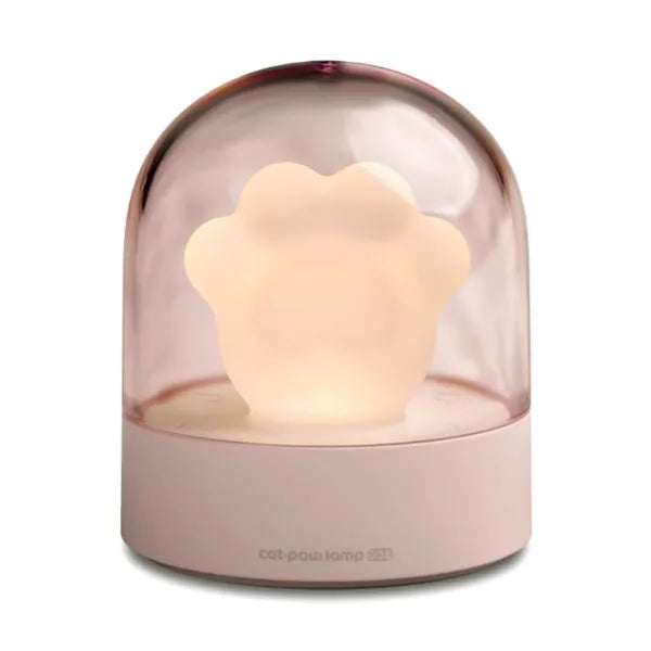 Grey cat paw shaped night light with USB port and button, glowing softly on a wooden desk.