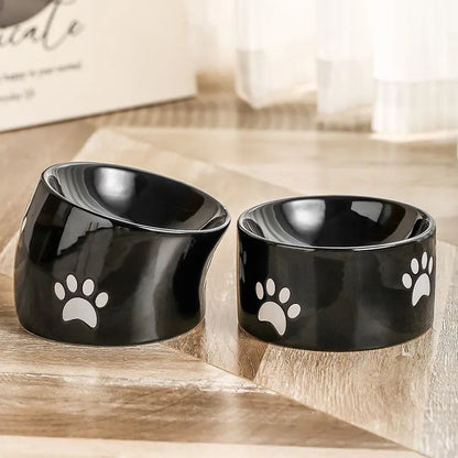 Ceramic cat bowl with high foot and cat's paw base in an oblique mouth design.
