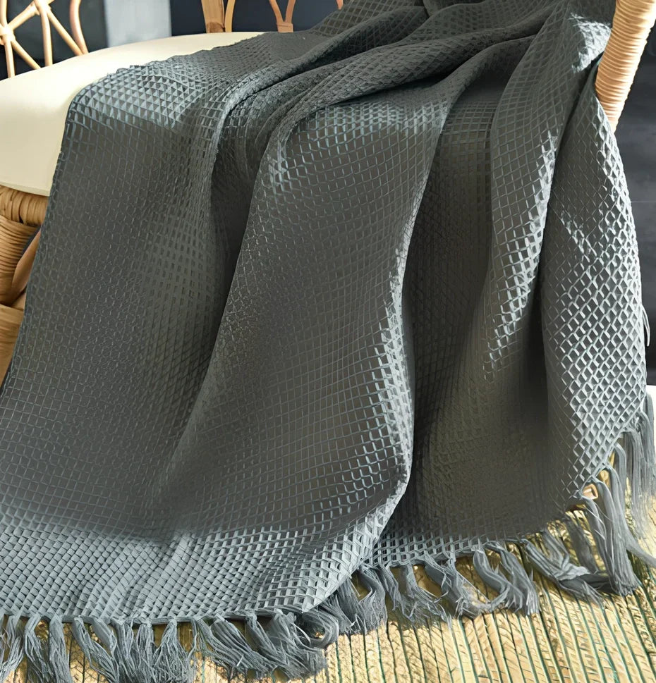 130x150cm knitted acrylic blanket with 10cm fringe detailing in beige colour draped over sofa